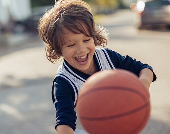 Laughing little boy playing basketball | Pediatric Dentist Andover MA 01810