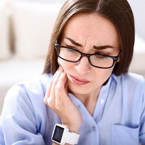 Woman in pain holding jaw | TMJ Dentist in Andover MA 01810