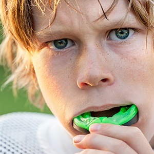 Teen boy placing sports mouthguard