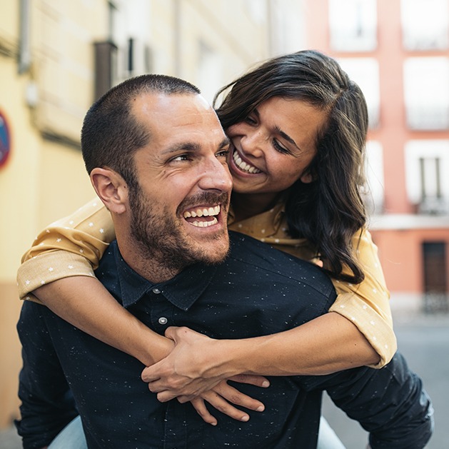 Smiling man and woman outdoors