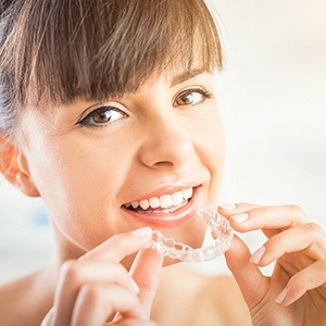 Woman placing Invisalign tray | Clear Aligners Dentist Andover MA 01810